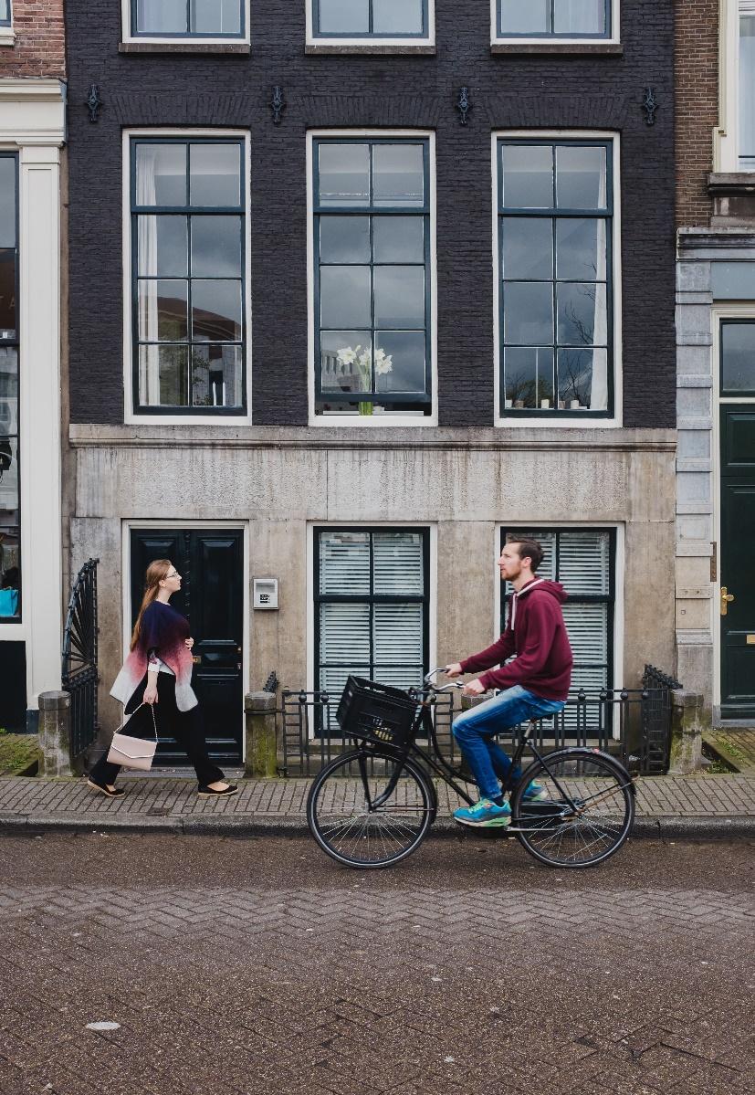 Man riding black city bike with black basket in front